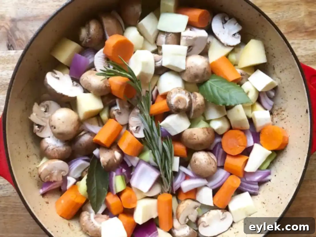 Vegetables and herbs simmering in a pot with beef drippings