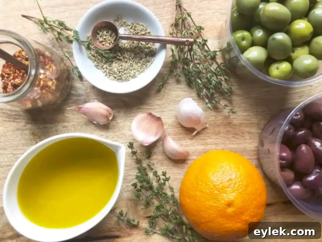 A bowl of Ina Garten's Warm Marinated Olives, featuring green and dark olives, orange zest, and fresh thyme, ready to serve.