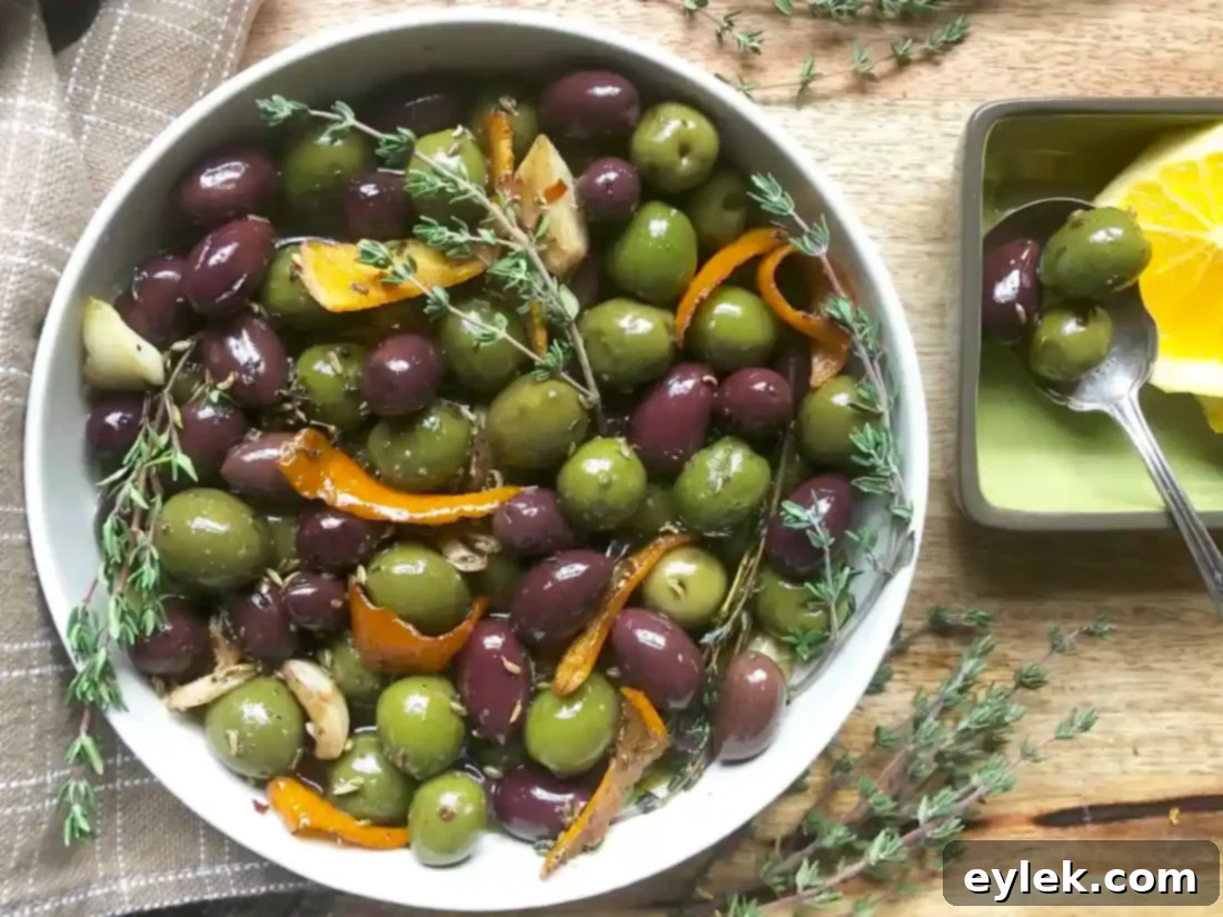 A beautiful spread featuring Ina Garten's Warm Marinated Olives, various cheeses, and fresh bread, ideal for entertaining.