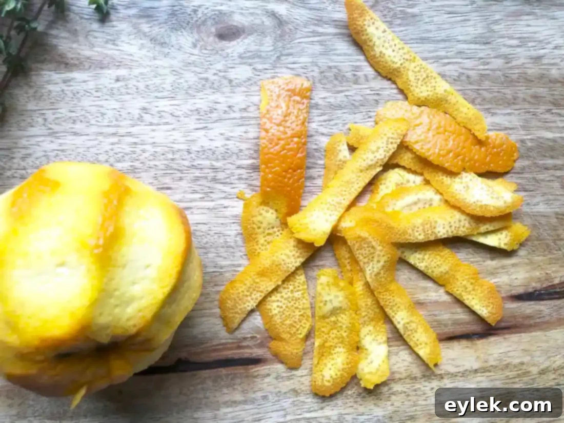 Close-up of orange zest strips on a cutting board, prepared for the olive marinade.