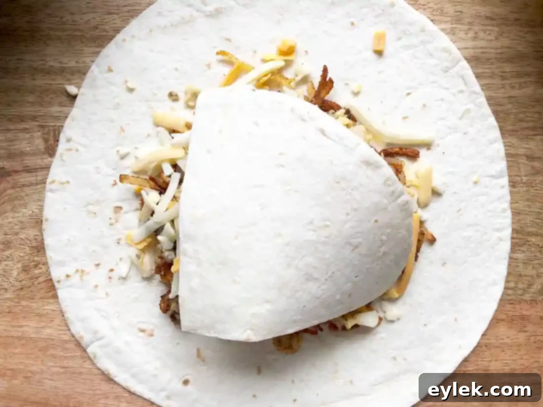 Folding the edges of the tortilla to seal the breakfast crunchwrap