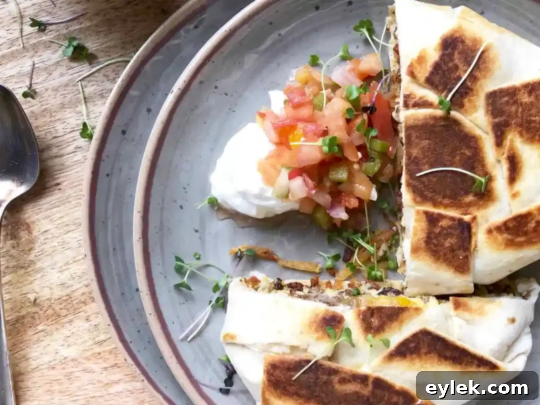 Two halves of a breakfast crunchwrap on a plate with toppings