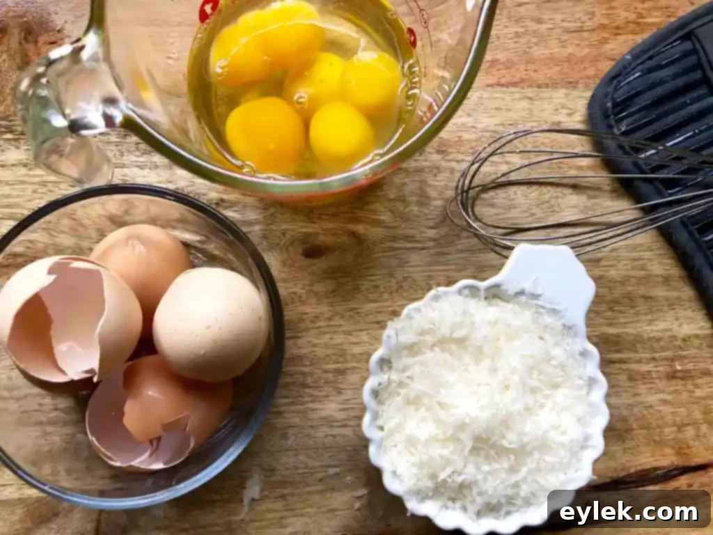 Whisked eggs and parmesan cheese in a bowl, prepared for the egg drop technique.