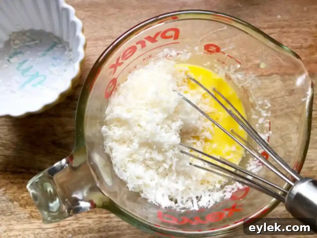 Tempering the egg and cheese mixture with hot broth, a crucial step for achieving delicate egg strands.