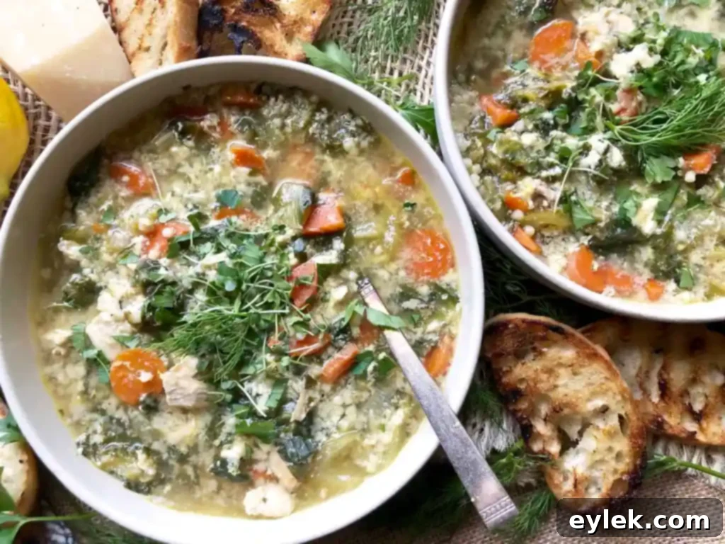 Delicious Chicken Escarole Soup with Egg & Pasta in a white bowl, garnished and ready to be enjoyed.