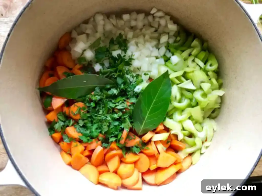 Sautéed vegetables, including carrots, celery, onion, parsley, and bay leaves, cooked until al dente.