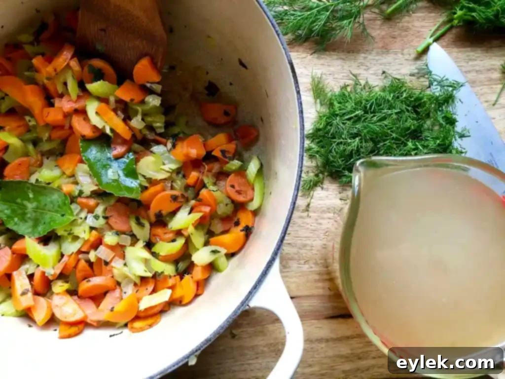 Adding chicken broth to the pot of sautéed vegetables and fresh dill.