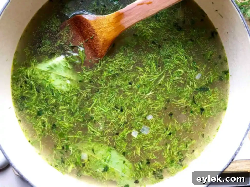 Chopped escarole added to the simmering chicken broth and vegetables for Chicken Escarole Soup with Egg & Pasta.