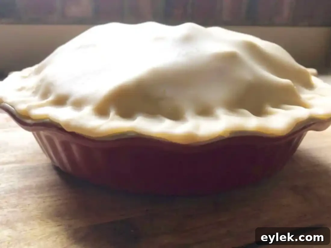 Sprinkling sugar and cutting vents on an unbaked apple pie