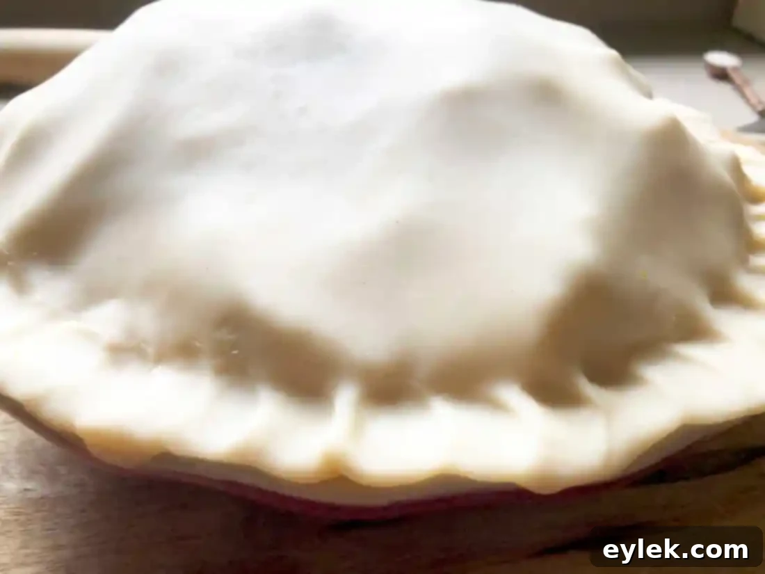 Deep Dish Apple Pie with egg wash and sugar, ready for oven