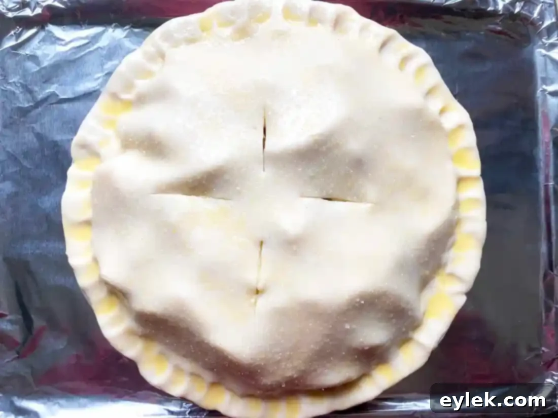 Deep Dish Apple Pie on a foil-lined baking sheet, ready for oven