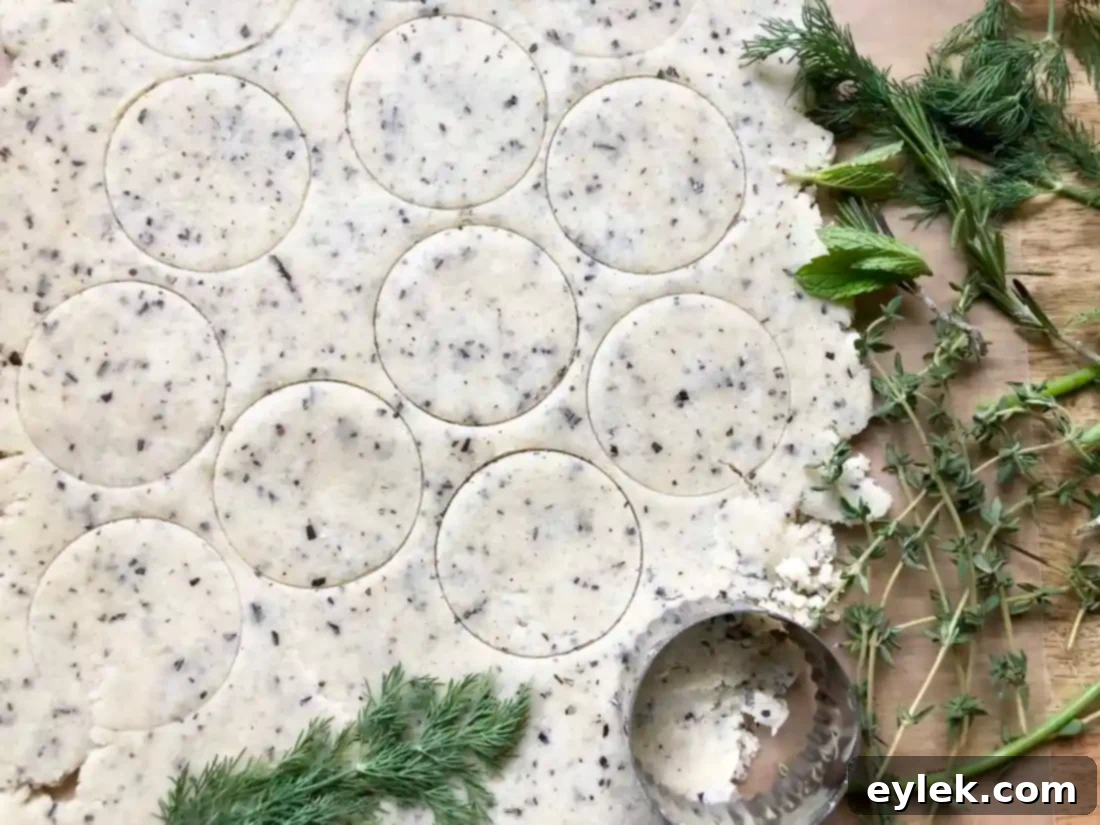 Placing fresh herbs on cracker dough
