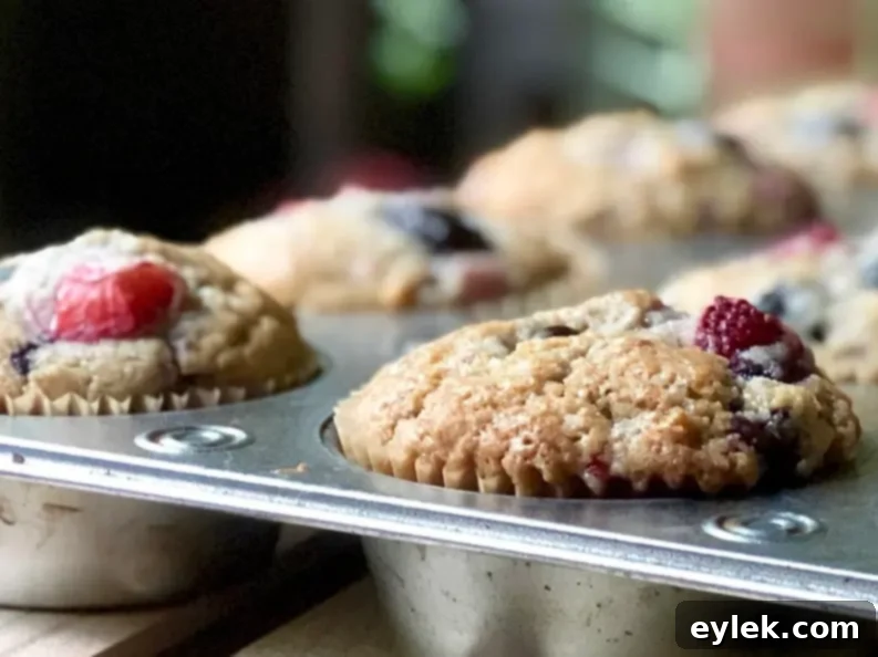 Triple Berry Muffins Gluten Free or Classic 12 The soft, fruit-filled interior of a sliced triple berry muffin