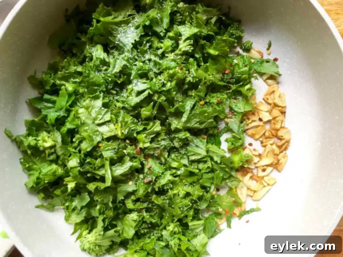 Broccoli rabe being sauteed with garlic in a skillet