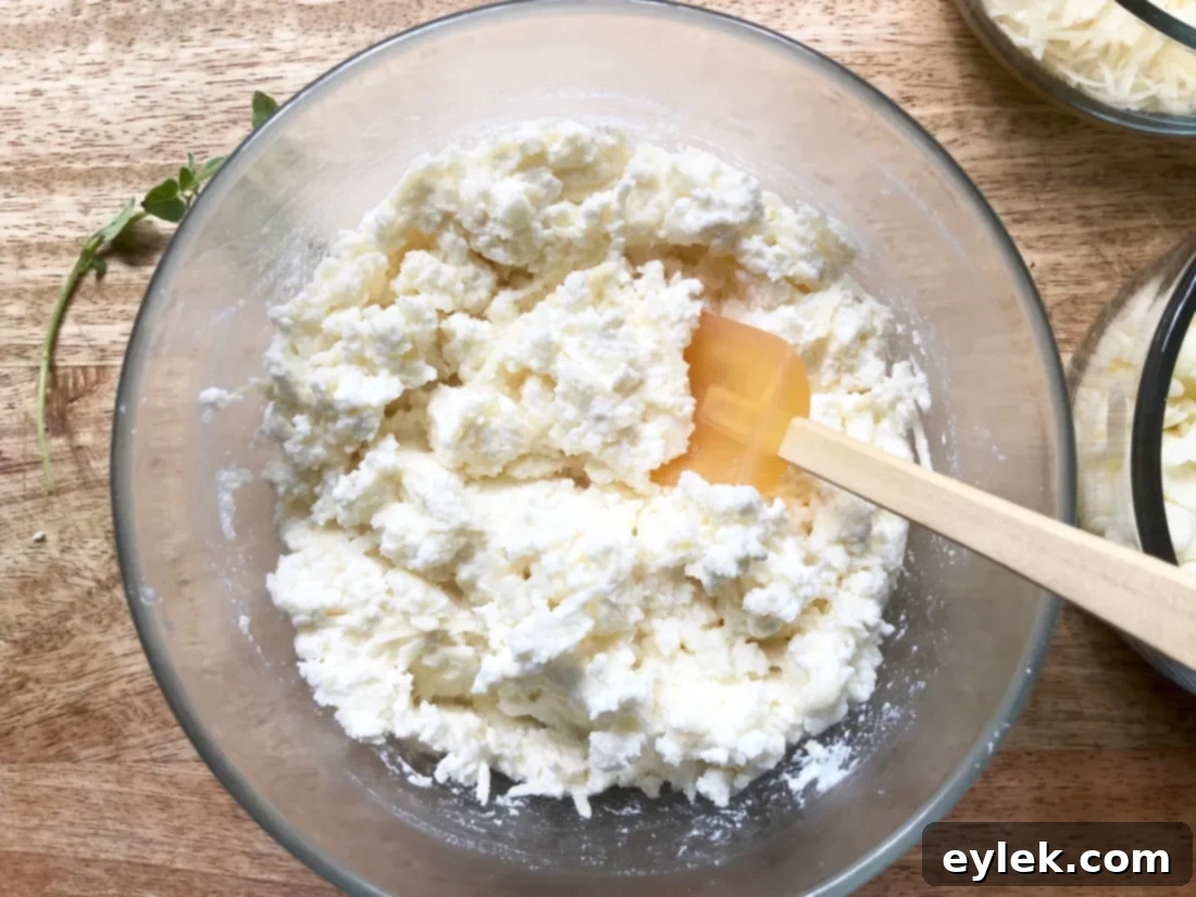 Preparing the ricotta, Parmesan, and mozzarella cheese mix for Quick & Easy Veggie Lasagna Cups.