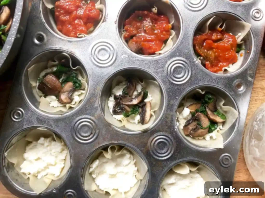 Adding the next layer of wonton wrapper over the initial filling in the lasagna cups.
