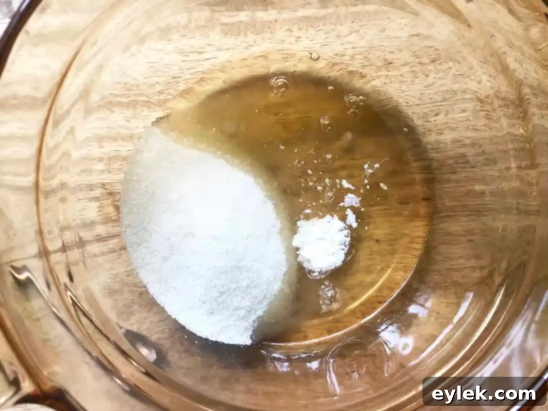 Egg whites, sugar, and cream of tartar whisking over a double boiler
