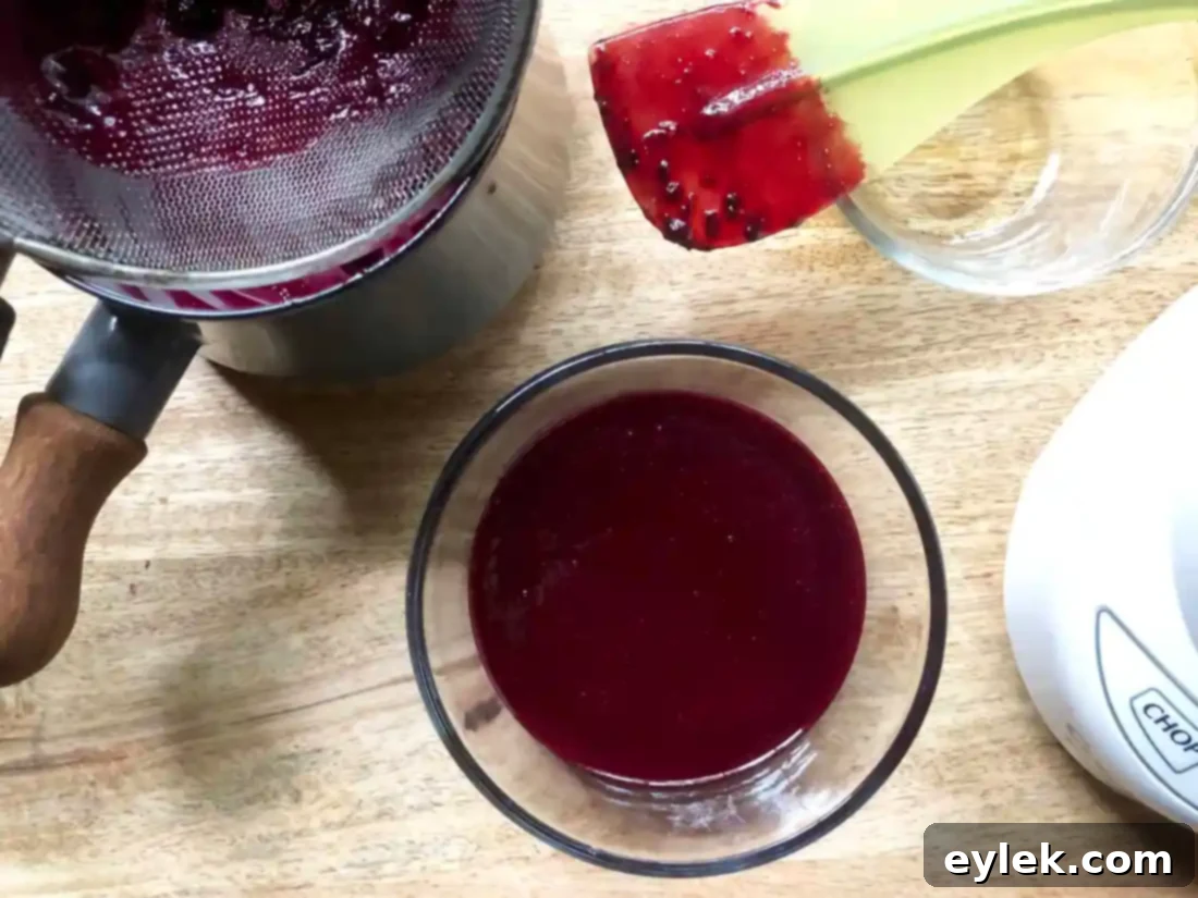 Straining blueberry puree through a fine-mesh sieve