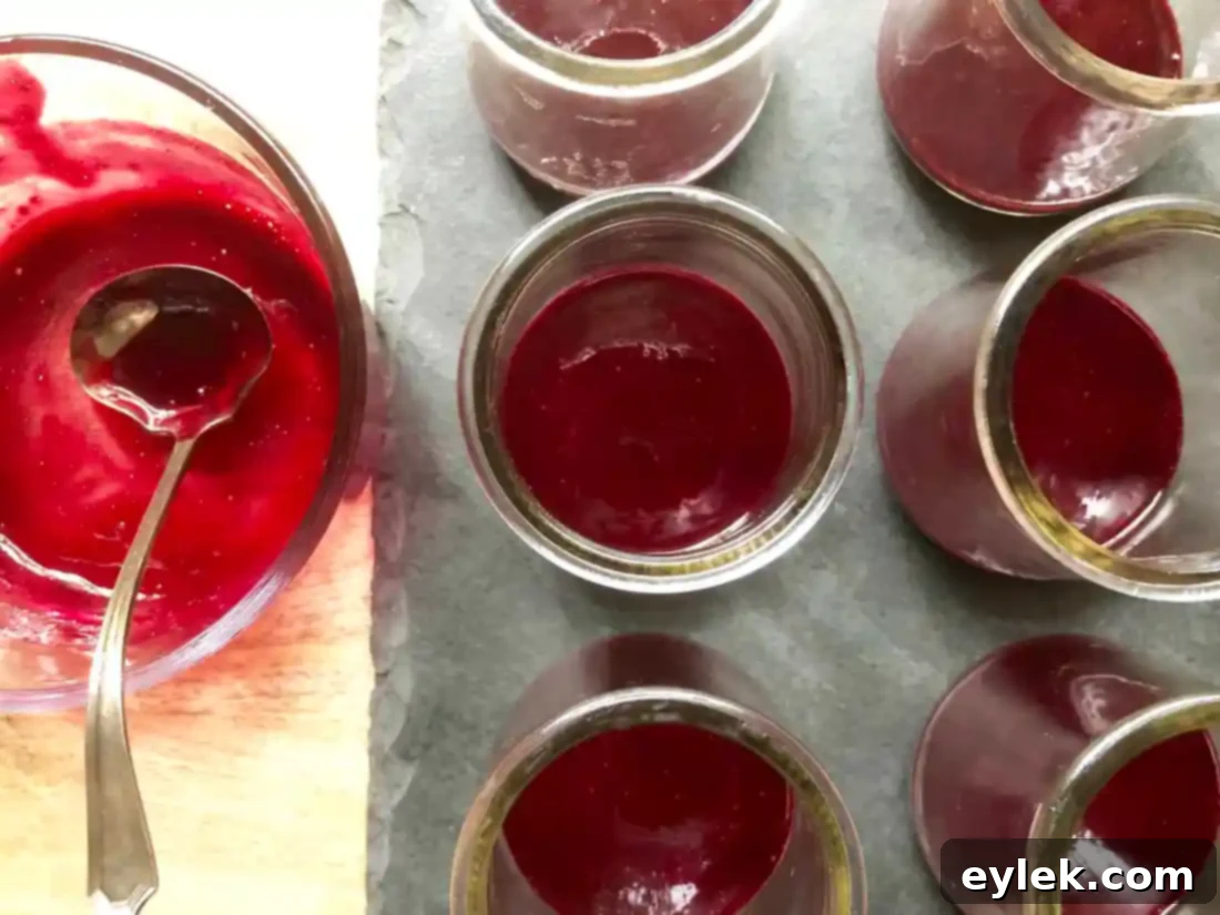 Blueberry sauce poured into glass ramekins, ready for chilling