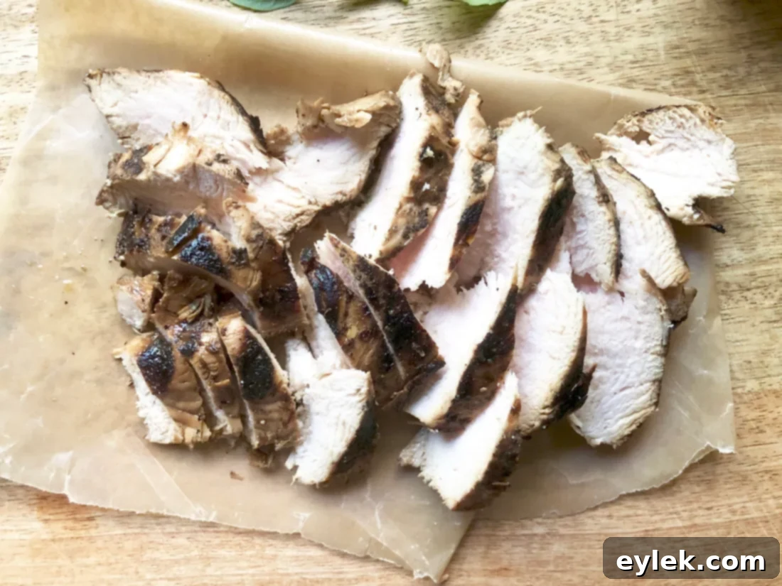 Close-up of grilled chicken breast slices, ready for a fresh salad