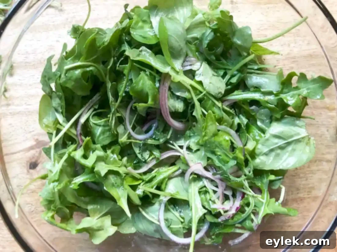 Arranging the dressed salad greens on serving plates