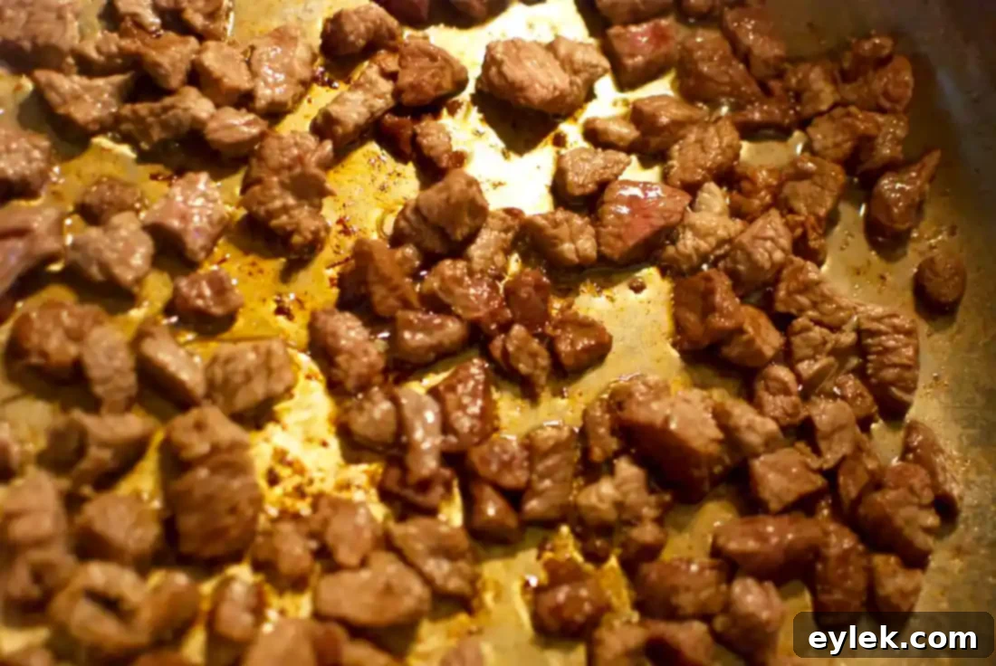 Cubed beef browning in a large pot for beef barley soup