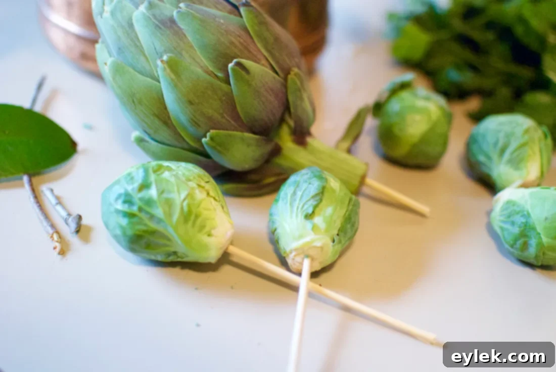 Close-up of a wooden skewer inserted into a baby artichoke, ready for floral arrangement