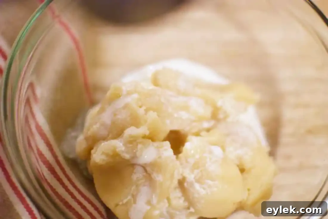 Almond paste and heavy cream being mixed with a fork for the cookie filling.