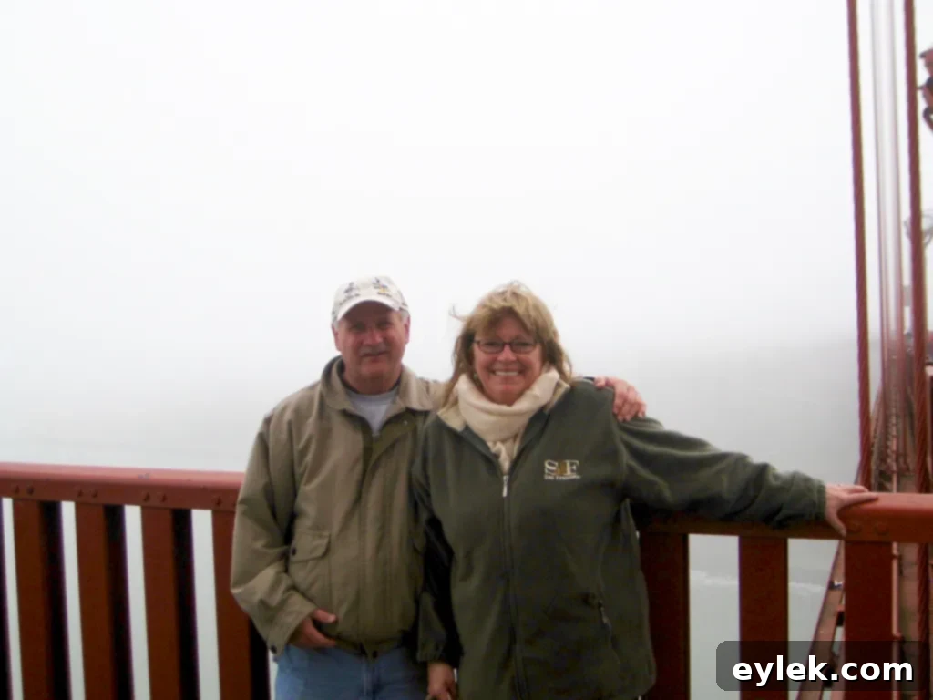 A couple riding bicycles on the Golden Gate Bridge, with the iconic orange towers and bay views.