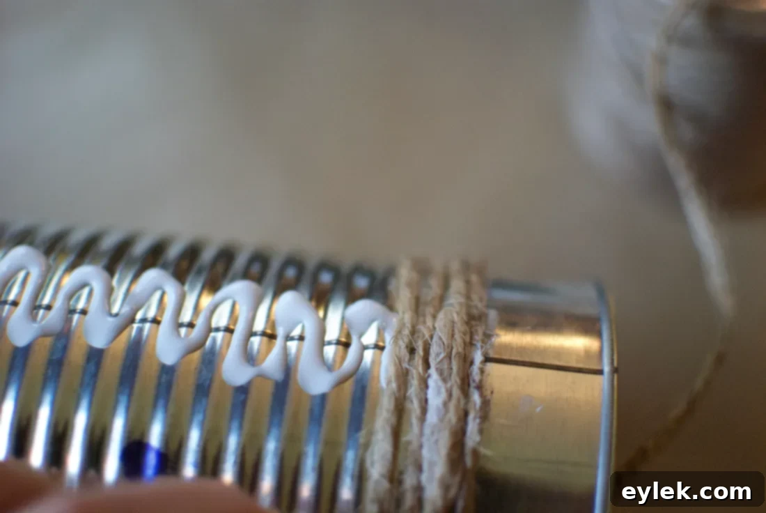 Applying craft glue along the ridged seam of a tin can as the first step for wrapping