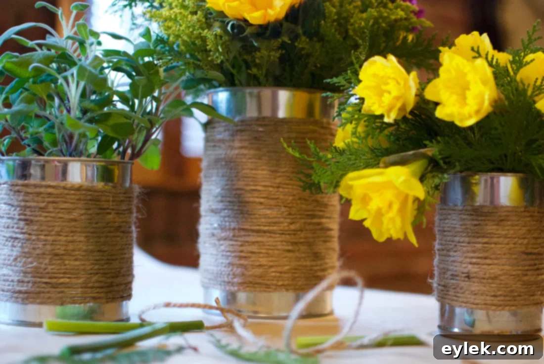 Two finished jute-wrapped tin can planters on a windowsill with blooming flowers