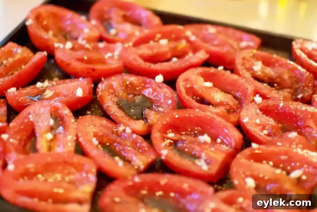 ina garten’s slow roasted tomatoes, tomatoes drizzled with oil and vinegar on a baking sheet