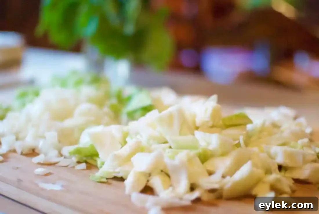 An array of fresh vegetables, including carrots, celery, onion, and herbs, prepped for The Ultimate Hearty Minestrone.