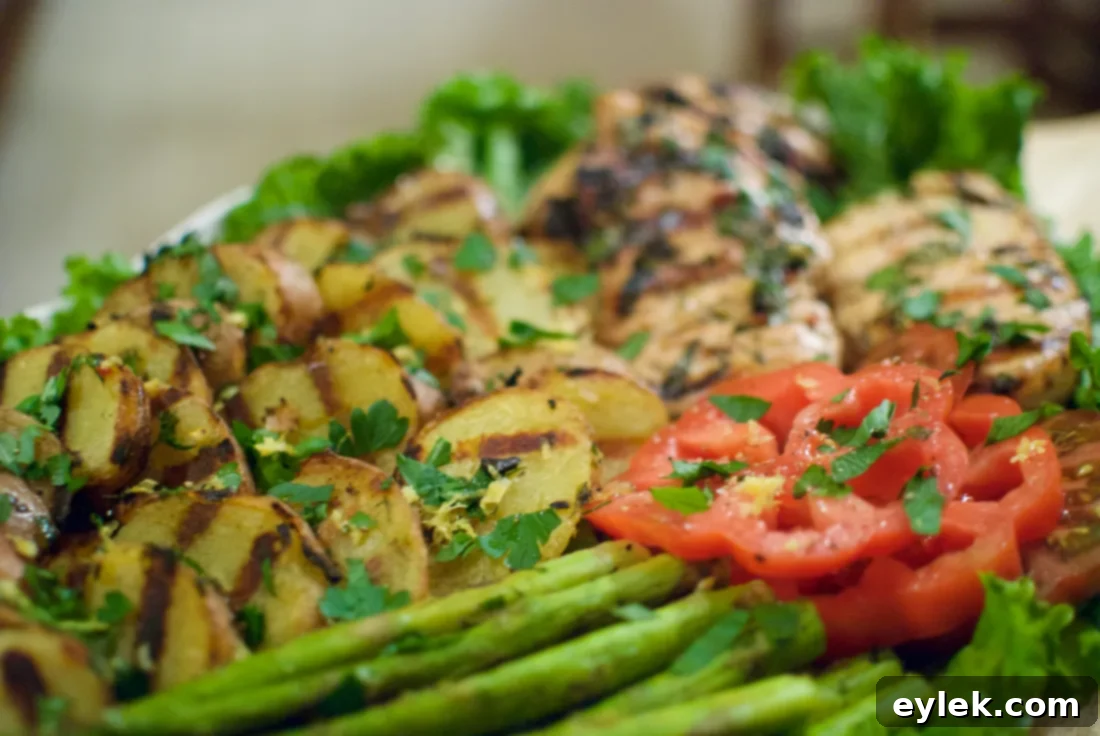 Overhead shot of a beautifully presented grilled lemon herb chicken dinner on a platter