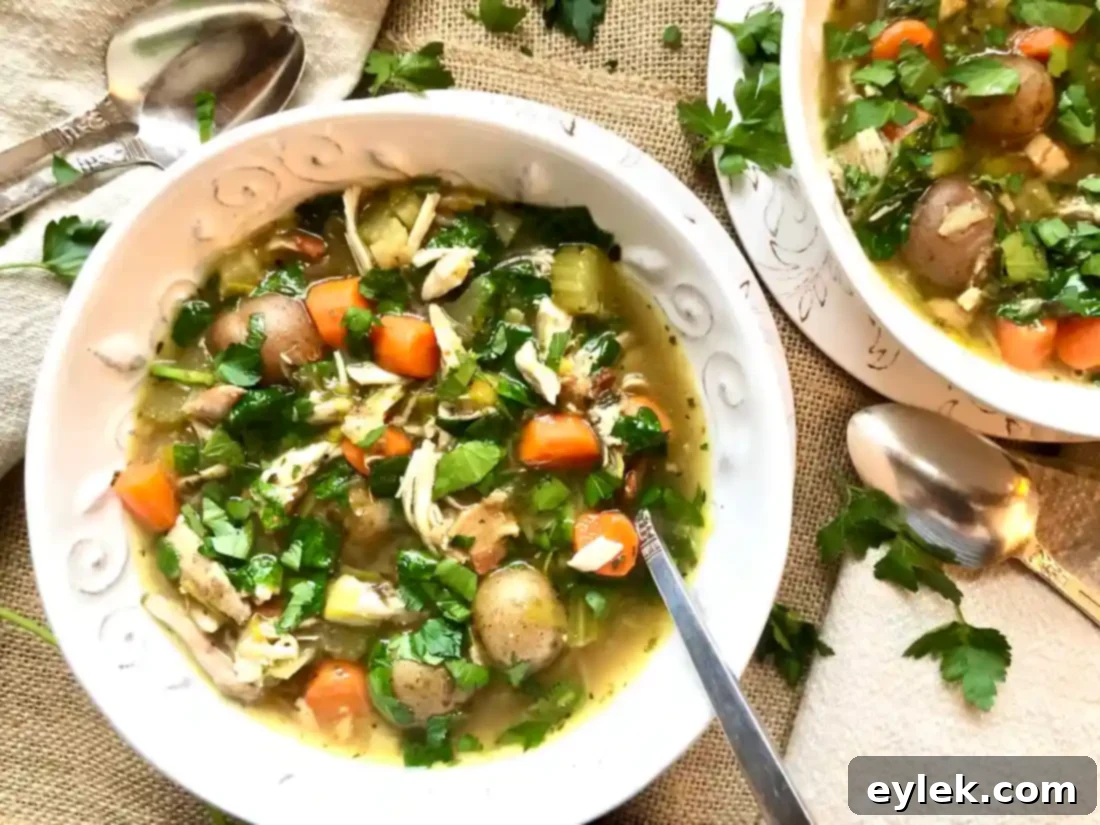 A bowl of Slow Cooker Chicken Soup with Bacon & Potatoes, garnished with fresh herbs