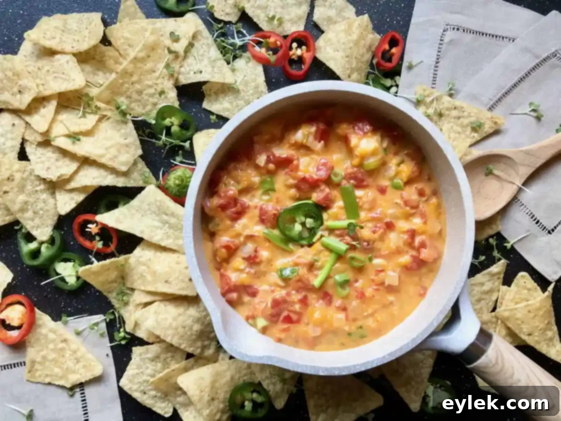Serving homemade queso dip with shrimp in a rustic saucepan, ready for a party.