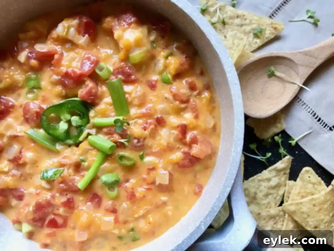 A festive spread of easy homemade queso dip with shrimp, surrounded by chips and fresh vegetables for dipping.