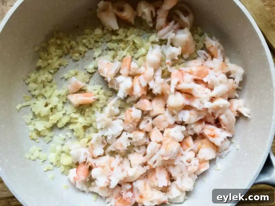 Cooked shrimp added to the fragrant onion and garlic mixture, warming through.