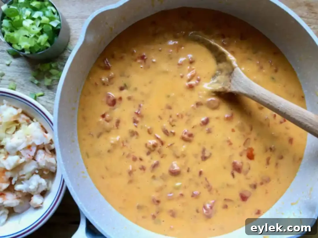 Shredded cheddar cheese melting into the tomatoes and chiles, forming the creamy queso base.