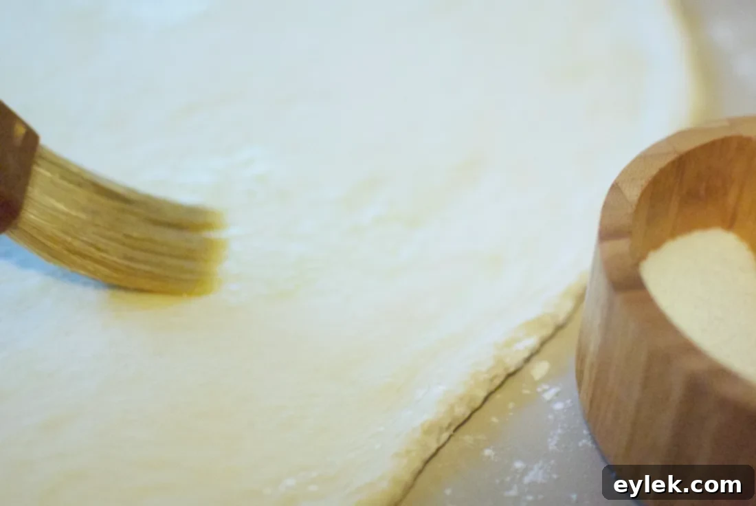 Hands stretching pizza dough on a floured surface