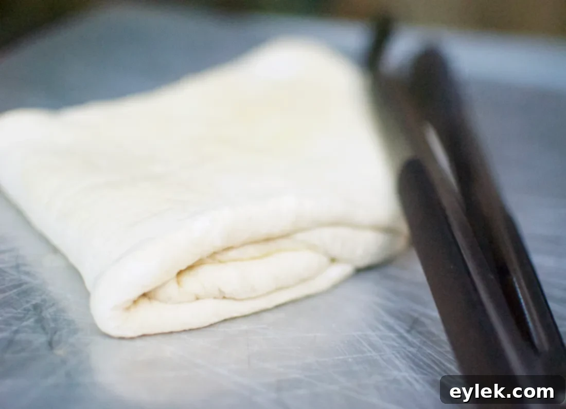 Pizza dough being placed onto a hot grill