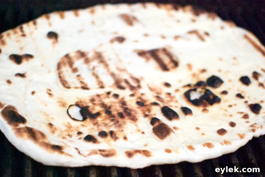 Grilled pizza crust with visible char marks on the second side
