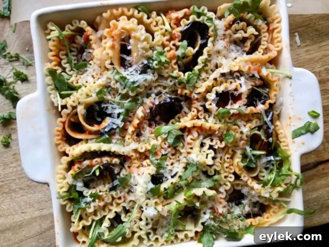 Arranged Sautéed Eggplant Lasagna Spirals filling a baking dish, showcasing the beautiful wavy edges and layered ingredients, perfectly ready for baking.
