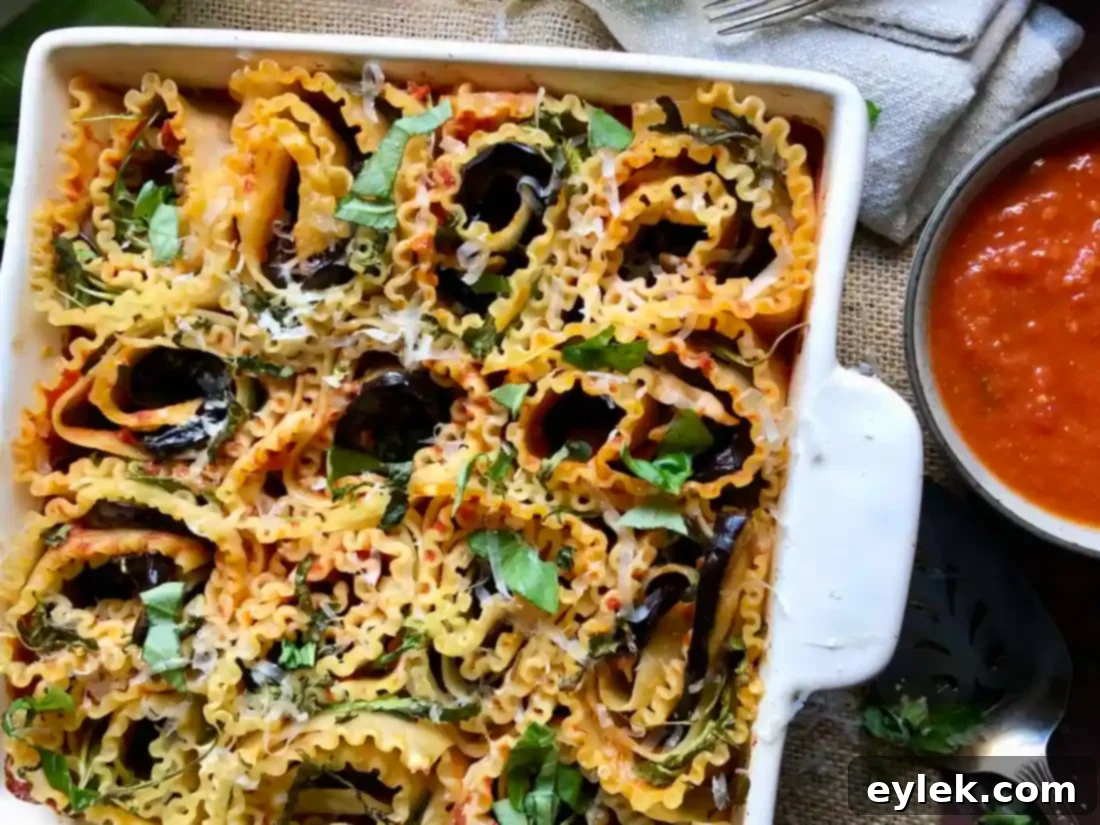 Freshly baked Sautéed Eggplant Lasagna Spirals, golden brown and bubbling with melted cheese and sauce, straight out of the oven, highlighting crispy wavy edges.
