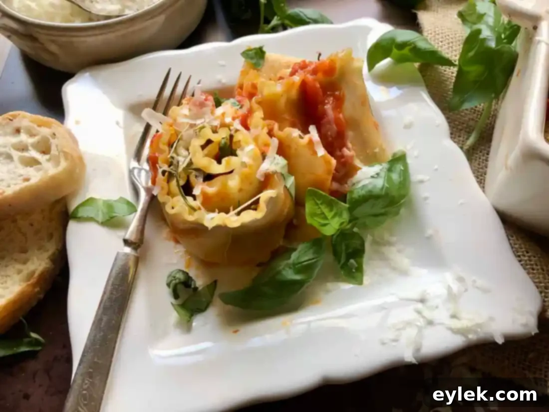 Close-up of golden-brown Sautéed Eggplant Lasagna Spirals in a baking dish, featuring melted cheese, rich sauce, and perfectly crisped wavy edges after baking.