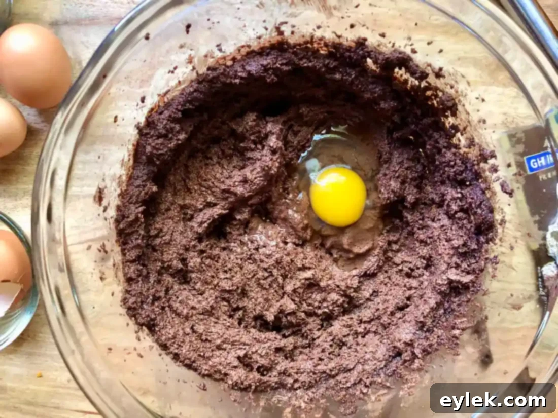 adding eggs to cookie batter