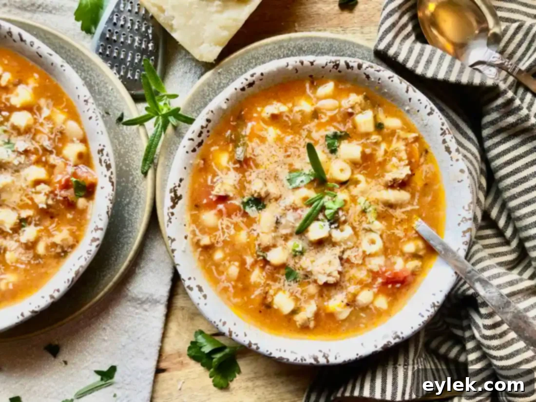 A large serving spoon scooping Pasta e Fagioli from a pot