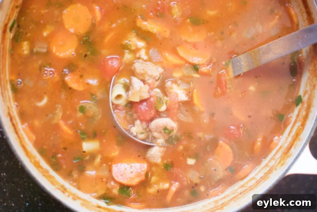 Close-up of a simmering pot of Pasta e Fagioli, rich with ingredients