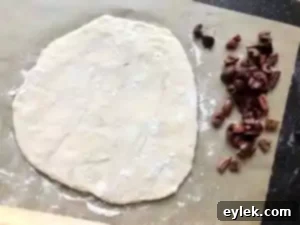 Shaping no-knead olive bread: dough flattened with olives, ready to be rolled