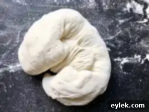 Shaped olive bread dough resting on parchment paper